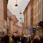 People stroll down a colorful city street.